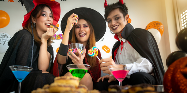 Three teens in costumes celebrating Hallowen